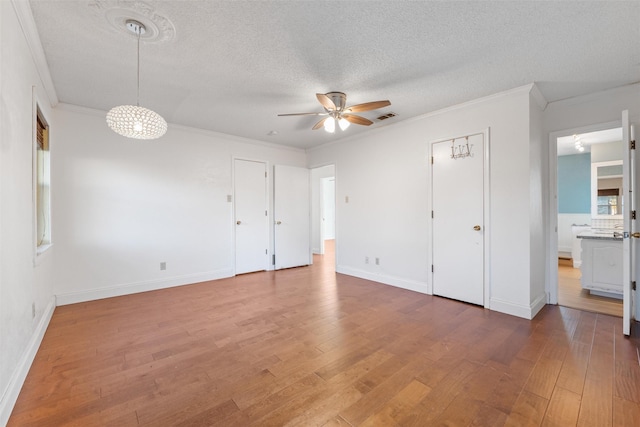 unfurnished bedroom with crown molding, hardwood / wood-style flooring, and a textured ceiling