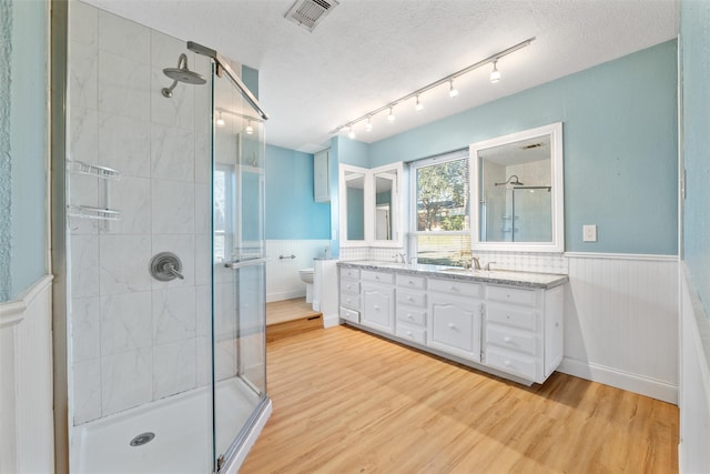 bathroom with vanity, hardwood / wood-style floors, a textured ceiling, and toilet