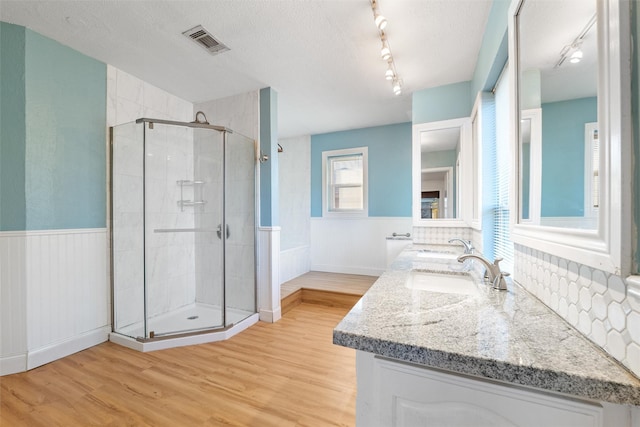 bathroom featuring hardwood / wood-style flooring, vanity, a textured ceiling, and a shower with shower door