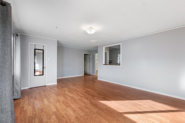 spare room with crown molding and light hardwood / wood-style floors