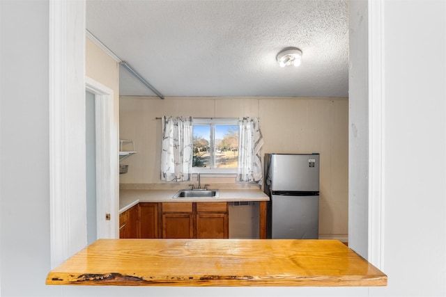 kitchen with sink, stainless steel appliances, and a textured ceiling