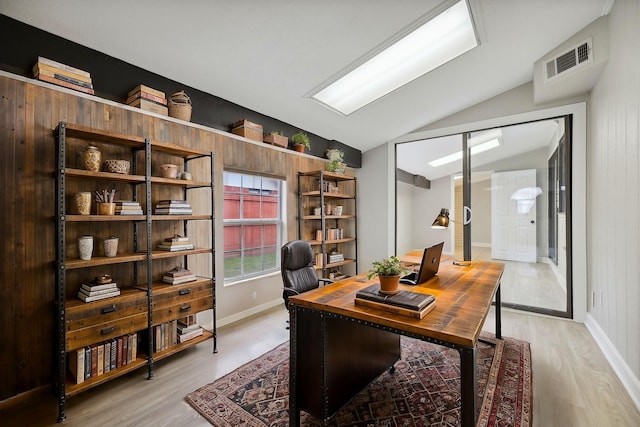 office featuring vaulted ceiling and light hardwood / wood-style flooring