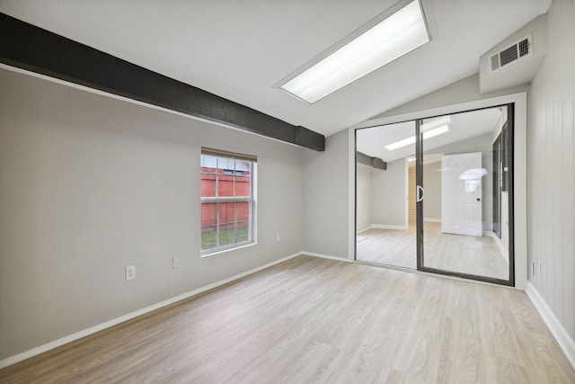 empty room with lofted ceiling and light hardwood / wood-style flooring