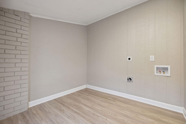 washroom featuring electric dryer hookup, hookup for a washing machine, ornamental molding, and light wood-type flooring