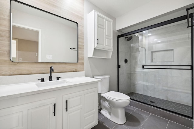 bathroom featuring tile patterned floors, vanity, toilet, and a shower with shower door