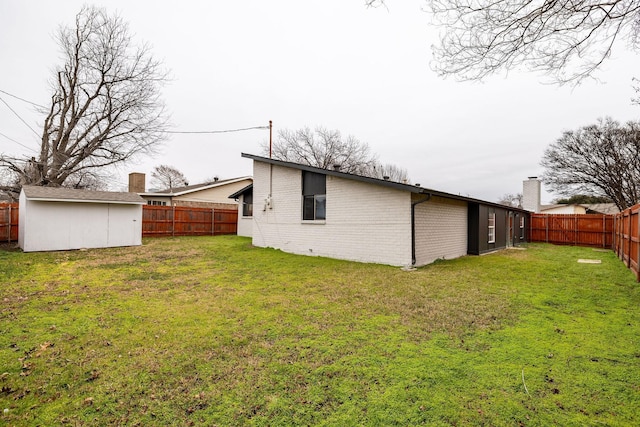 rear view of house with a shed and a yard