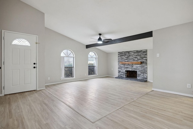 unfurnished living room featuring ceiling fan, lofted ceiling, a fireplace, and light hardwood / wood-style flooring