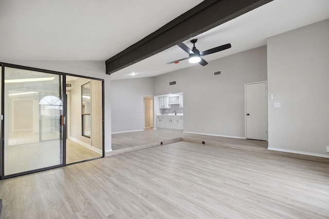 spare room featuring ceiling fan, light hardwood / wood-style floors, and lofted ceiling with beams