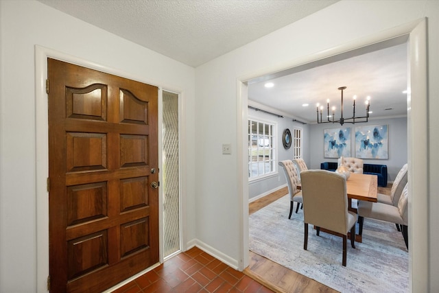 foyer with a textured ceiling and a notable chandelier