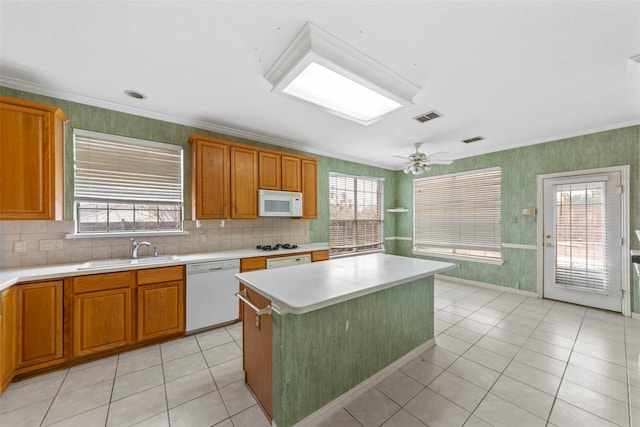 kitchen featuring sink, white appliances, plenty of natural light, and a kitchen island