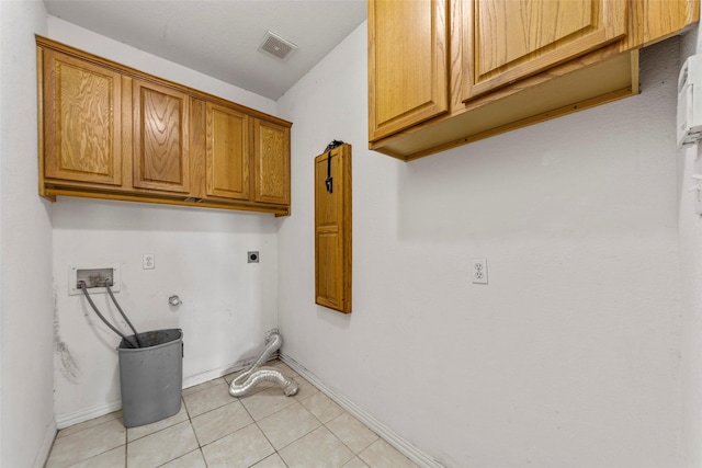 laundry area with gas dryer hookup, cabinets, light tile patterned floors, hookup for a washing machine, and electric dryer hookup