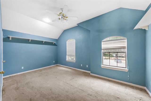 carpeted spare room featuring lofted ceiling and ceiling fan