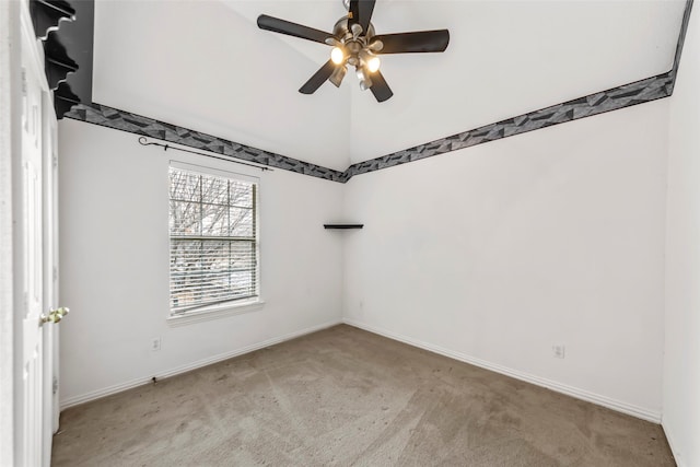 spare room featuring ceiling fan, light colored carpet, and vaulted ceiling