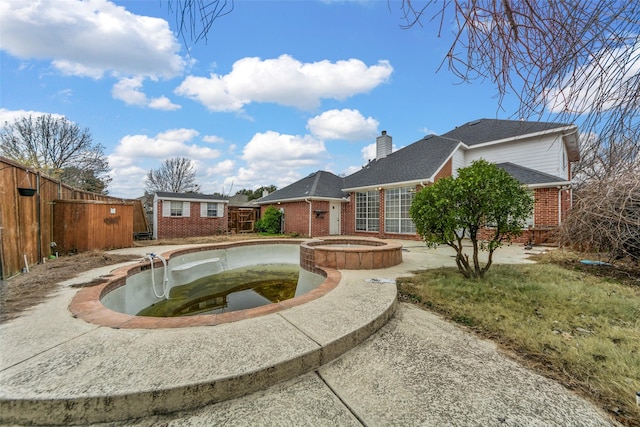 view of swimming pool with an in ground hot tub