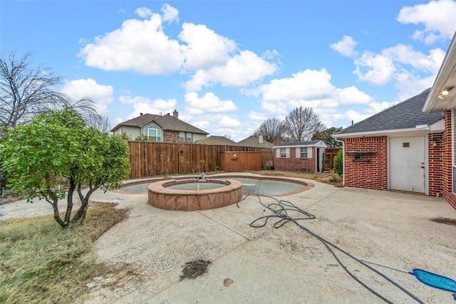 view of swimming pool featuring an in ground hot tub, an outdoor structure, and a patio area