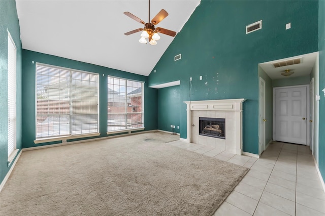 unfurnished living room featuring ceiling fan, light colored carpet, a fireplace, and high vaulted ceiling