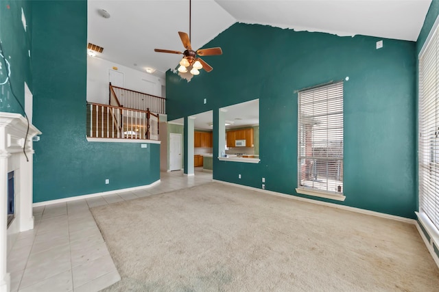 unfurnished living room with high vaulted ceiling, ceiling fan, and light tile patterned flooring