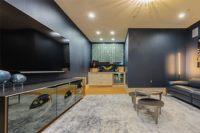 living room with wine cooler, bar, and light wood-type flooring