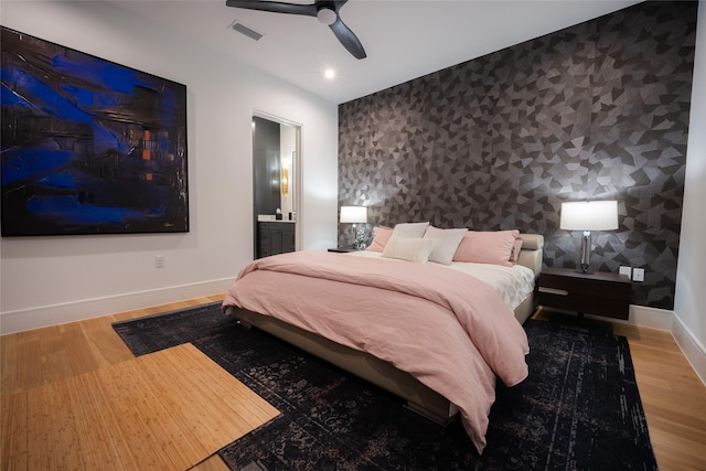 bedroom featuring hardwood / wood-style flooring, ceiling fan, and ensuite bathroom