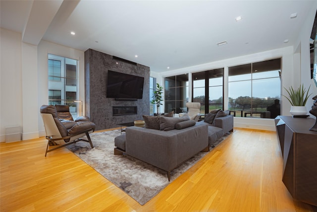 living room with wood-type flooring and a large fireplace