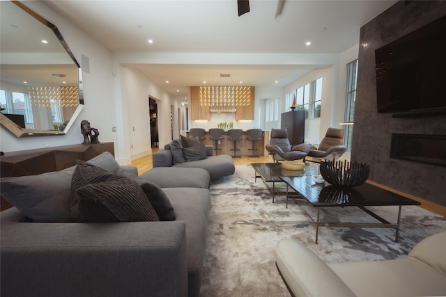 living room with light hardwood / wood-style floors and a large fireplace