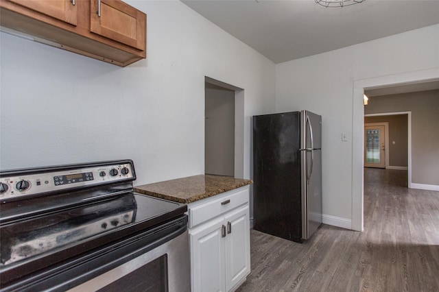 kitchen with dark stone countertops, stainless steel appliances, dark hardwood / wood-style flooring, and white cabinets