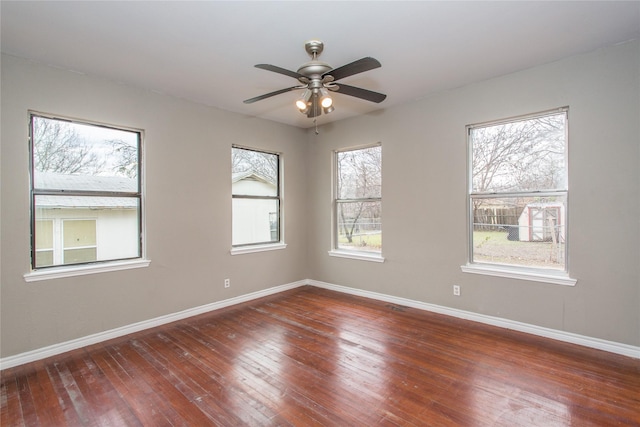 spare room featuring dark wood finished floors, baseboards, and ceiling fan