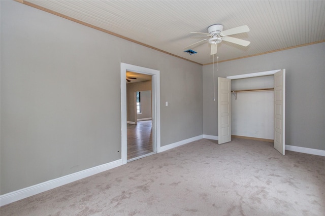 unfurnished bedroom featuring light carpet, crown molding, a closet, and ceiling fan