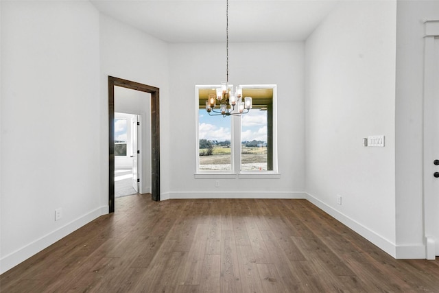 unfurnished dining area featuring an inviting chandelier and dark hardwood / wood-style flooring