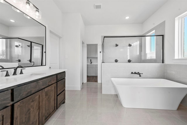 bathroom featuring vanity, tile patterned floors, and plus walk in shower