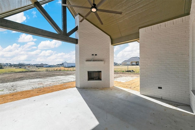 view of patio / terrace with ceiling fan and a fireplace