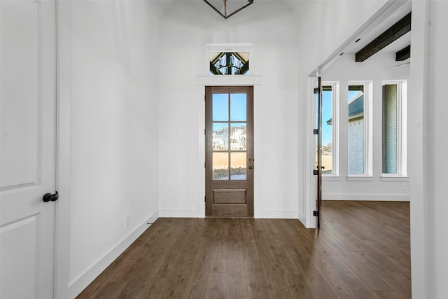 entryway with dark wood-type flooring and beam ceiling