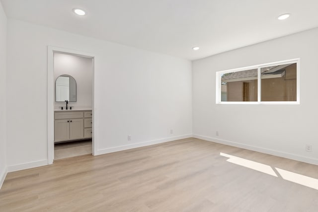 spare room featuring sink and light hardwood / wood-style flooring