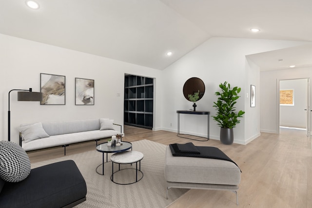 living room featuring vaulted ceiling and light wood-type flooring