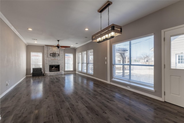 unfurnished living room featuring a fireplace, ornamental molding, and dark hardwood / wood-style floors