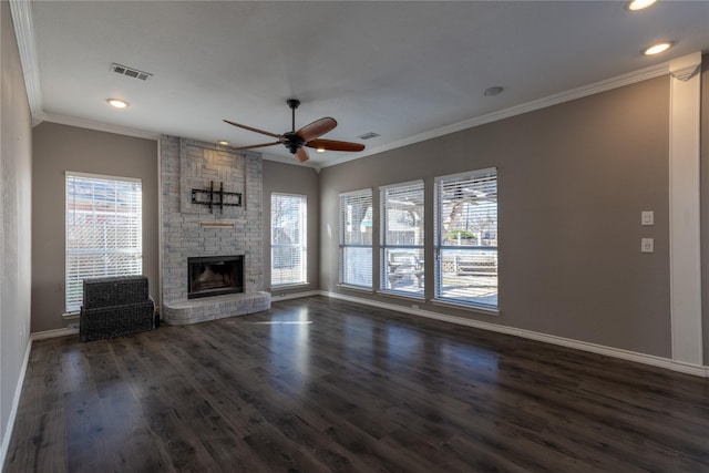 unfurnished living room with a fireplace, plenty of natural light, dark hardwood / wood-style floors, and ornamental molding