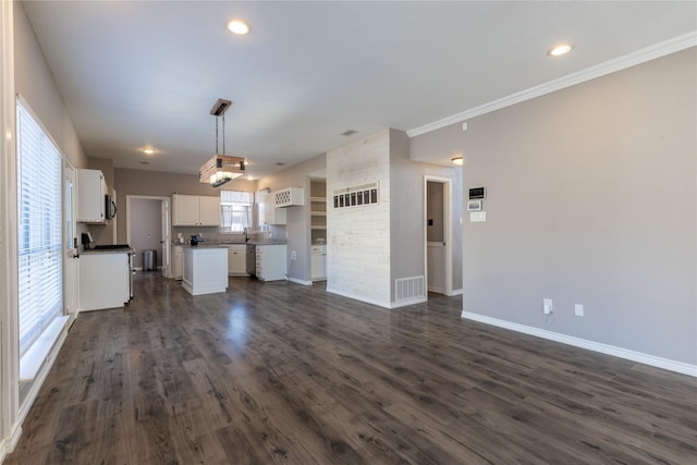 unfurnished living room featuring crown molding, dark hardwood / wood-style floors, and sink