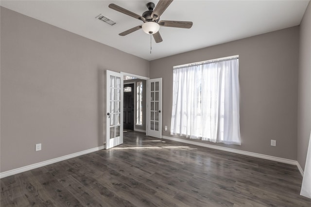 spare room featuring dark wood-type flooring, ceiling fan, and french doors