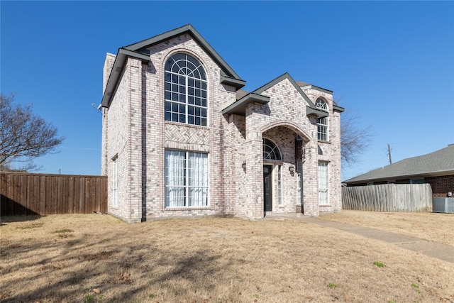 view of front property with central AC and a front yard