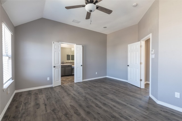 unfurnished bedroom featuring dark hardwood / wood-style floors, connected bathroom, lofted ceiling, sink, and ceiling fan