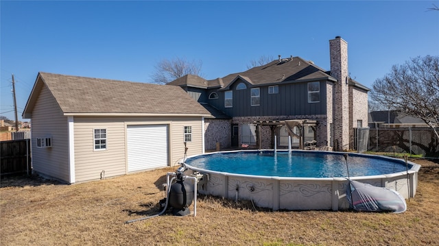 rear view of house with a yard, a pergola, and a fenced in pool