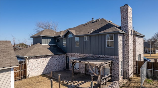 rear view of house featuring a pergola and a patio area