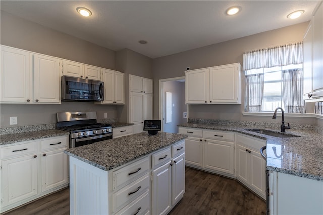 kitchen featuring sink, a kitchen island, white cabinets, and appliances with stainless steel finishes