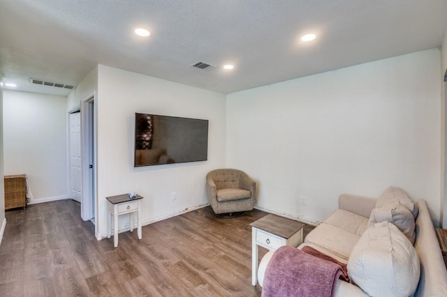 living room featuring hardwood / wood-style flooring and a textured ceiling