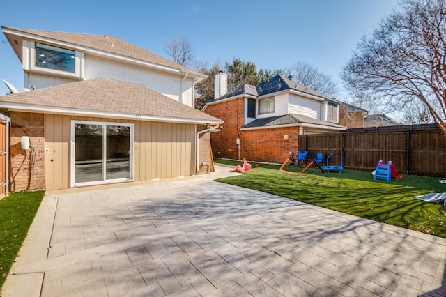 rear view of property with a playground, a yard, and a patio area