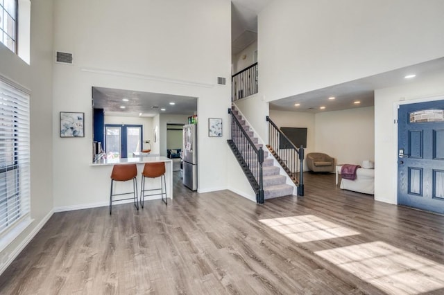 interior space featuring light hardwood / wood-style flooring and a high ceiling