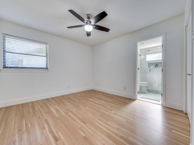 unfurnished bedroom with ceiling fan, ensuite bathroom, and light wood-type flooring