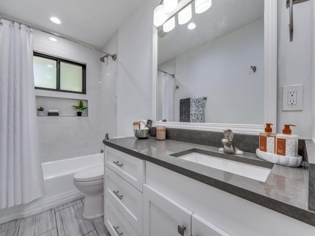 full bathroom featuring vanity, shower / bath combination with curtain, and toilet