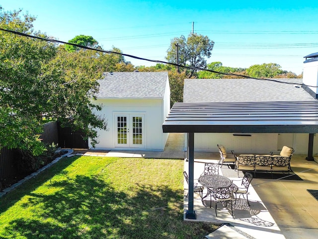 rear view of house featuring a patio, an outdoor structure, a yard, and french doors