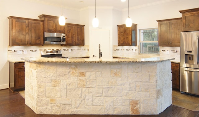 kitchen featuring stainless steel appliances, dark hardwood / wood-style floors, light stone counters, and decorative light fixtures